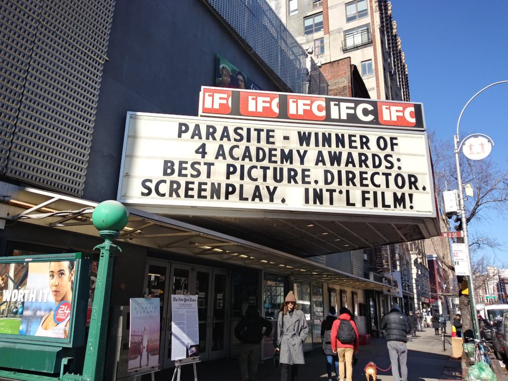 A black and white marquee celebrating the win of the film "Parasite."